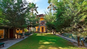 A hotel with a central tower, surrounded by a well-maintained lawn and trees. - Sanur, Elegant 2 Bed Villa
 (Sanur)