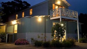 A two-story building with a balcony, a large window, and a door. - Howards Hill bed & breakfast (cape schanck)