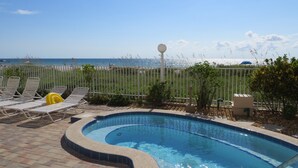 A swimming pool with lounge chairs and a view of the ocean. - Direct Beach Front - Updated Unit - Last Minute July Special! (Indian Shores)