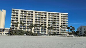 A multi-story hotel with balconies, located near a beach with palm trees. - Direct Beach Front - Updated Unit - Last Minute July Special! (Indian Shores)