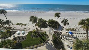 A beach view with palm trees, a pool area, and a beachside walkway. - Direct Beach Front - Updated Unit - Last Minute June Special! (Indian Shores)