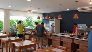 A restaurant with wooden tables and chairs, a buffet counter, and hanging pendant lights. - 🌺RIVIERA APARTMENT WITH SEA VIEW (send message before) (Bertioga)