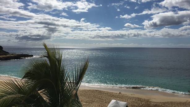 A beach with clear skies and calm sea. - Cozy Beach front condo in Makaha (Waianae)