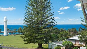 A large pine tree in front of a lighthouse and ocean view. - Pilotage 4 - Luxury Ocean and River View Penthouse - Holiday Yamba (Yamba)