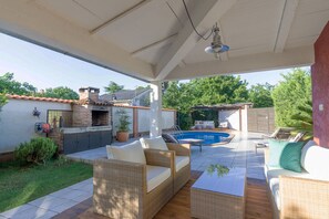 A covered outdoor patio with wicker furniture, a pool, and a brick oven. - Villa Dana near the beach and the center of the town 6+2 (Pula)