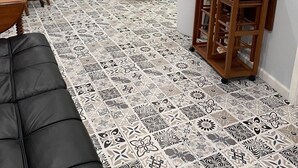 Ein kompakter Wohnbereich mit Küchenzeile, Essbereich und einer Sitzecke mit schwarzem Sofa.