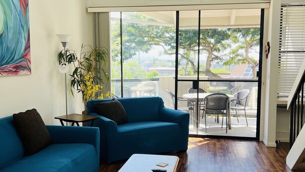 Una sala de estar moderna con un sofá azul, una mesa de centro de madera y un ventilador de techo.