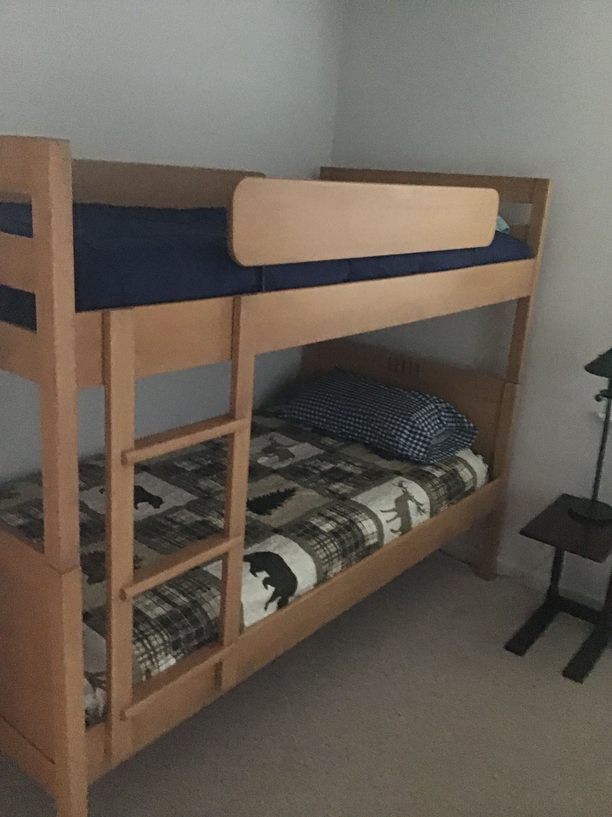 Un letto a castello con materasso blu e coperta a motivi.