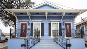 A two-story house with a blue exterior, a front porch with a black railing, and a number '503' sign on the door. - TOP LOCATION! Luxury Traditional New Orleans Home, Heart of NOLA (New Orleans)