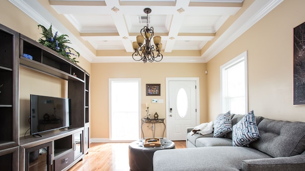 A living room with a sectional sofa, a flat-screen TV, a dark wood entertainment center, and a chandelier. - TOP LOCATION! Luxury Traditional New Orleans Home, Heart of NOLA (New Orleans)