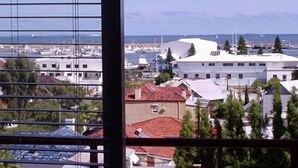 Rannikkokaupunki, jossa on rakennuksia, vierasvenesatama ja näkymä merelle.