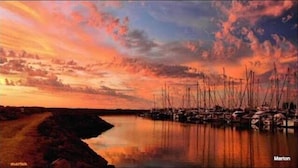Veneilyvenesatama, jossa veneet ovat ankkuroituina auringonlaskun aikaan.