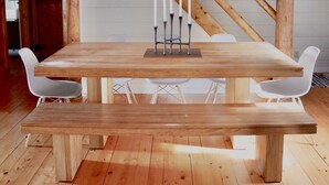 A wooden dining table with a bench, white chairs, and a white paper lantern hanging from the ceiling. - Your Maine Lake Escape — Waterfront, Peaceful, Pet-Friendly (Sullivan)
