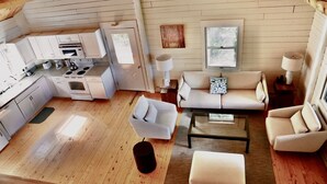 A compact living space with a kitchenette, a sofa set, and a coffee table. - Your Maine Lake Escape — Waterfront, Peaceful, Pet-Friendly (Sullivan)