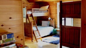 A wooden cabin interior with a bunk bed, a ladder, and a bookshelf. - Your Maine Lake Escape — Waterfront, Peaceful, Pet-Friendly (Sullivan)