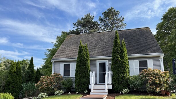 A two-story house with a front porch, a chimney, and a well-maintained lawn. - Family Cottage Close to Beach!! (Harwichport)