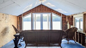 A log cabin with a high ceiling and large windows. - Picturesque Adirondack Lake Home (Greig)