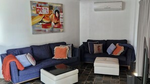 Una sala de estar con dos sofás, una mesa de centro y un televisor.
