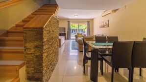 A modern interior with a staircase, a dining area, and a view of a courtyard. - Fabulous, spacious townhome steps from Eagle Beach (Oranjestad)