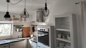 A modern kitchen with white cabinetry, a built-in oven, and pendant lights. - Villa Danica with private pool and WIFI Near Center Of The Town And 2km Beach (Pula)