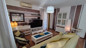 A living room with a sofa, TV, and a cabinet with glass doors. - Villa Danica with private pool and WIFI Near Center Of The Town And 2km Beach (Pula)
