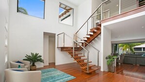 Ein geräumiger Wohnbereich mit einer Holztreppe, einem Sofa und einem Couchtisch.