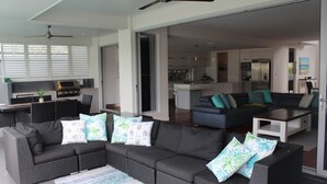 Ein modernes Wohnzimmer mit einem dunkelgrauen Sofa, einem Couchtisch und einem gemusterten Teppich.
