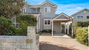 A two-story house with a covered porch and a stone wall with the number 136. - Hamptons Escape - Magnificent views (Gerroa)