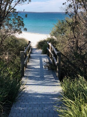 A paved pathway leading to a beach with a wooden railing on both sides. - Cottage @Callala Beach - Pet friendly / Trampoline / Cubby house / Free wi-fi (Callala Beach)