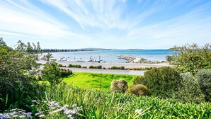 A coastal landscape with a road leading to a marina, surrounded by greenery and clear skies. - Magnificent Views Over the Bay (Encounter Bay)