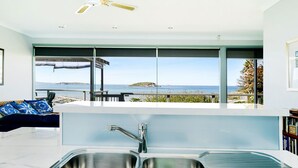 A modern kitchen with a large window overlooking a scenic coastal view. - Magnificent Views Over the Bay (Encounter Bay)