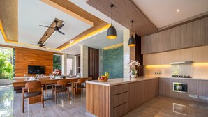 Een moderne keuken met een centraal eiland, houten kastjes en een ingebouwde oven.