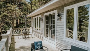 A wooden deck with outdoor furniture, including chairs and a table. - Amazing Views All Seasons White Lake/Channel Spacious Easy Walk to Lake Michigan (Montague)