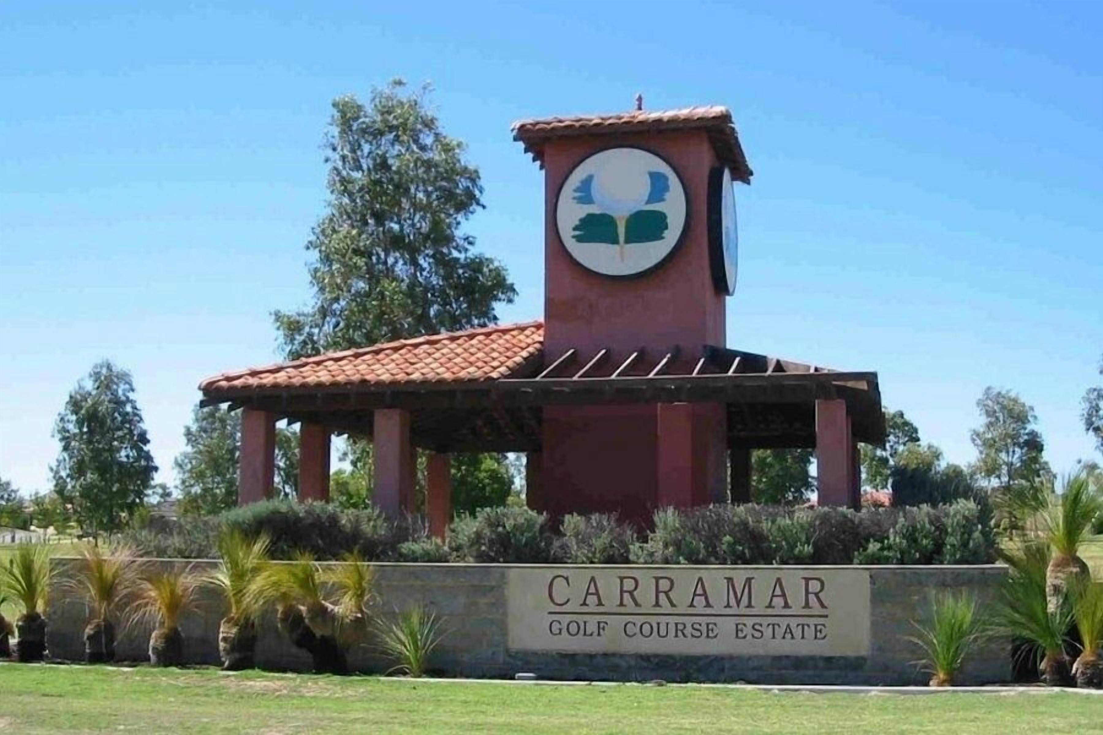A building with a sign that reads "Carramar Golf Course Estate."
