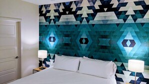 A hotel room with a bed, two bedside tables with lamps, and a geometric patterned wall. - Centrally located in Uptown Charlotte.  Gym, Pool and Free Parking.  Walk everywhere! (Charlotte)