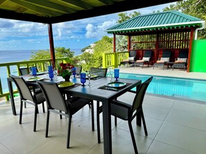 A dining area with a view of the sea, a pool, and a gazebo. - Stunning, Beachfront, Sunset Views, Turtle Point 4 bedroom villa W Private Pool (Port Elizabeth)