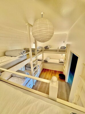 A bunk bed room with a hanging light fixture and a wooden floor. - BEACHFRONT OASIS.4 BEDROOMS. SLEEPS 14.PETS WELCOME. (Rosedale)
