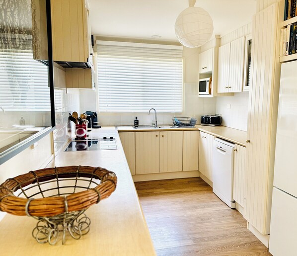 A kitchen with white cabinets, a wooden countertop, a microwave, and a dishwasher. - BEACHFRONT OASIS.4 BEDROOMS. SLEEPS 14.PETS WELCOME. (Rosedale)