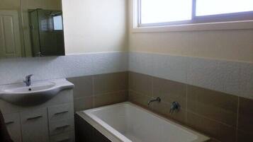 Bathtub, hair dryer, towels, toilet paper