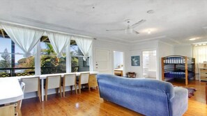 Relax in this spacious room with a sofa, dining area, and bunk bed, offering a comfortable space for rest and relaxation.