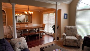 A dining area with a wooden table and chairs, a chandelier, and a large mirror. - Lakefront Oasis Centrally Located. Elegant, spacious and you're going to love it (Virginia Beach)