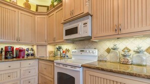 Una cocina con armarios de madera, una estufa blanca y un microondas.