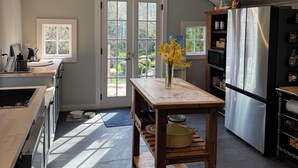 Una cocina moderna con tragaluz, una mesa de madera y un refrigerador.