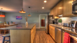 A modern kitchen with wooden cabinets, a central island, stainless steel appliances, and pendant lighting. - Sweet Suite! Modern, Pool, 2RM, 2BA, Ski Resort 532 (Killington)