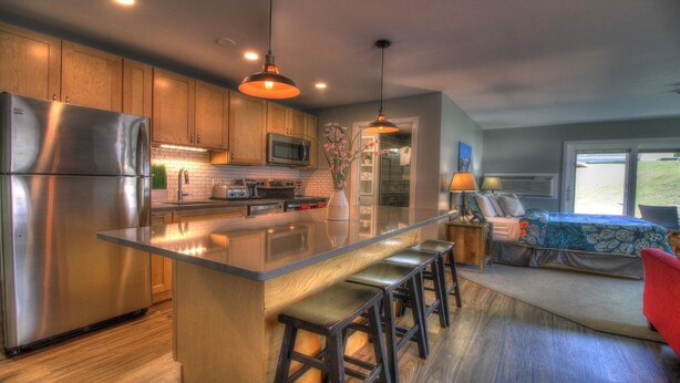 A modern kitchen with a central island, stainless steel appliances, and wooden cabinets. - Sweet Suite! Modern, Pool, 2RM, 2BA, Ski Resort 532 (Killington)
