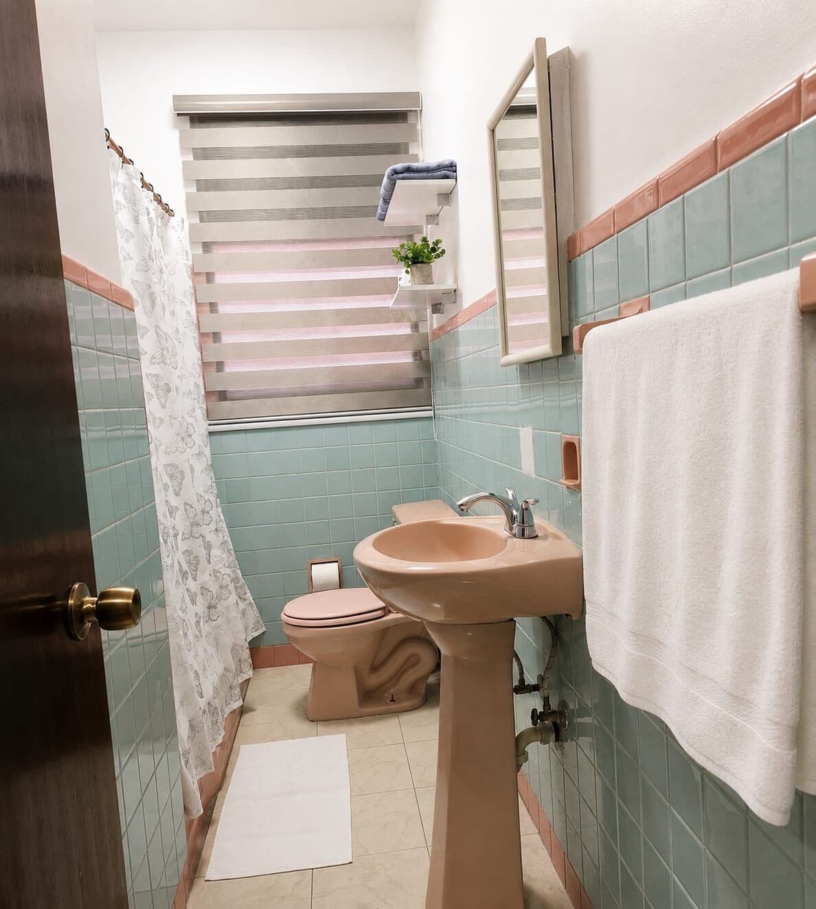 A bathroom with a toilet, sink, and shower curtain.