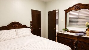 A bedroom with a bed, dresser, and a window with blinds. - Condado Lagoon View - Apartment at Miramar: Beach, Night Life, family and more!! (San Juan)