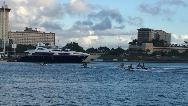 A large yacht docked near a marina with several speedboats in the water. - Condado Lagoon View - Apartment at Miramar: Beach, Night Life, family and more!! (San Juan)