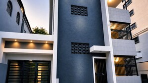 A modern building with a dark facade, multiple balconies, and a gated entrance. - Condado Lagoon View - Apartment at Miramar: Beach, Night Life, family and more!! (San Juan)