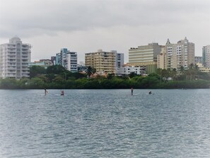 A waterfront cityscape with buildings and a calm body of water.